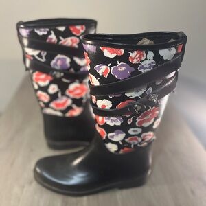 Coach Trisha II black and floral canvas rubber rain boots.